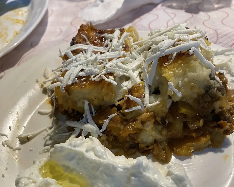 A portion of moussaka with yoghurt