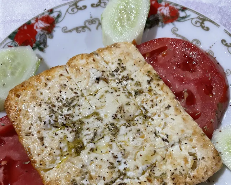 Golden fried cheese with oregano on sliced tomatoes
