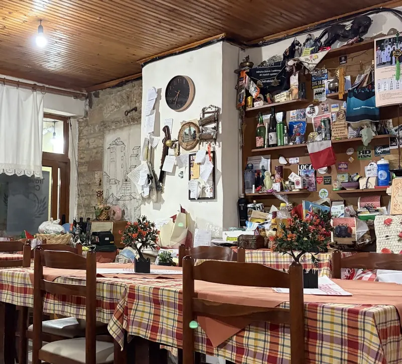 The dining room with a wooden ceiling, checked tablecloths and shelves of keepsakes